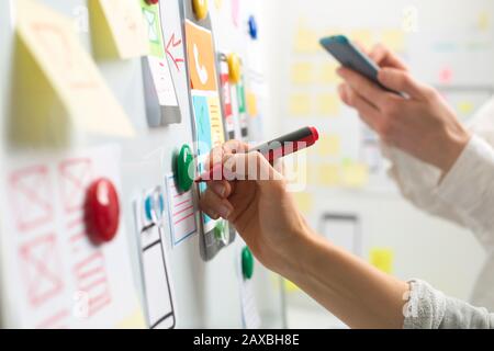 UI website designers are developing a mobile phone application interface. User experience Stock Photo