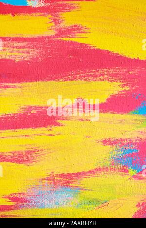 Abstract texture of plaster from wavy lines from a brush of red yellow and blue. Close up. Stock Photo