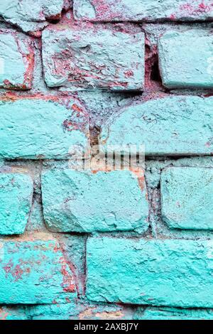 A crumbling brick wall as a texture painted turquoise color. Close up. Stock Photo