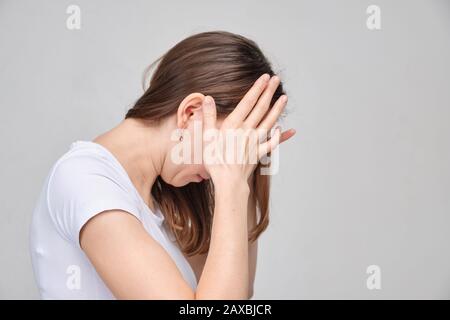 A girl in a white T-shirt massages the lower abdomen. close up Stock Photo  - Alamy