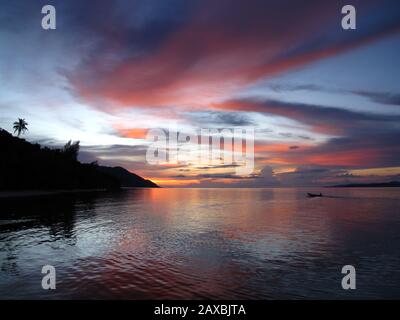 Silhouette on Raja Ampat with the sunset reflected on the yellow sea Stock Photo