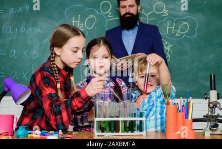 children making science experiments. Education. chemistry lab. happy children teacher. back to school. doing experiments with liquids in chemistry lab. Checking the results. Stock Photo