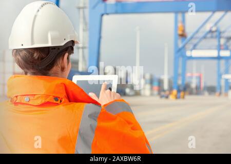 Female dock worker using digital tablet at shipyard Stock Photo