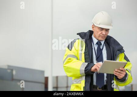 Dock manager using digital tablet at shipyard Stock Photo