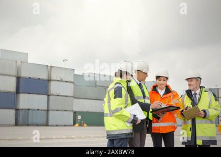 Dock workers and manager talking at shipyard Stock Photo