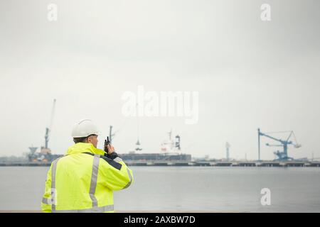 Dock worker with walkie-talkie at commercial dock Stock Photo