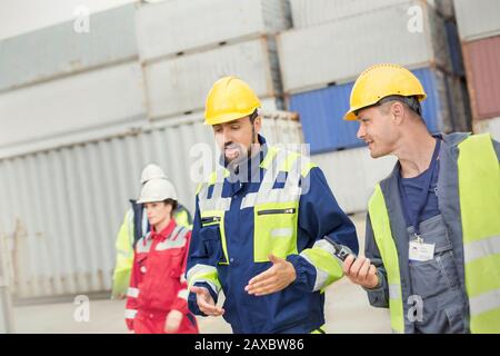 Dock workers walking and talking at shipyard Stock Photo