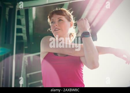 Young female runner stretching arm Stock Photo