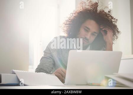 Focused young man working at laptop Stock Photo