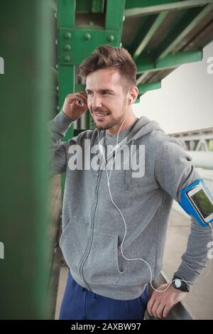 Young male runner with mp3 player arm band and headphones Stock Photo