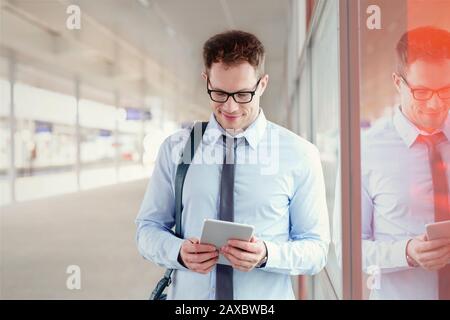 Businessman using digital tablet in train station Stock Photo