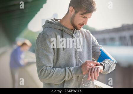 Young male runner checking smart watch Stock Photo