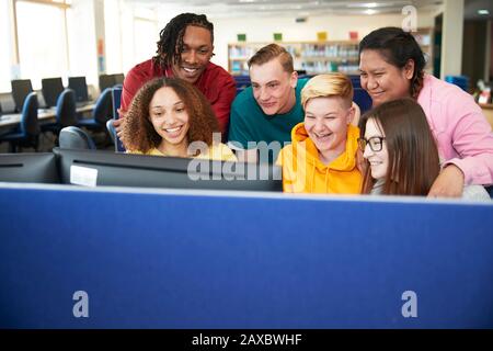 High school students using computer in library Stock Photo