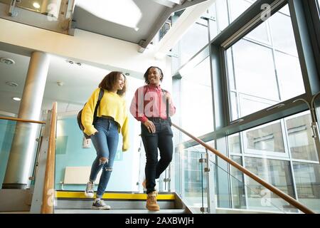 Smiling college students descending staircase Stock Photo
