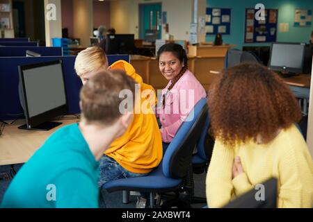 Happy college students talking and studying in library Stock Photo