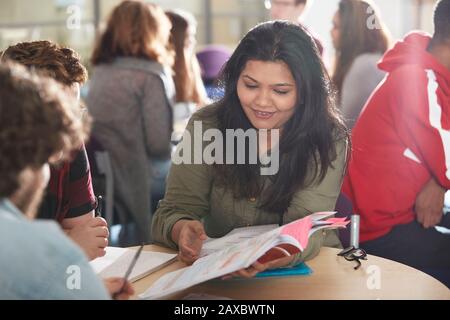 Smiling high school girl student studying with classmates Stock Photo