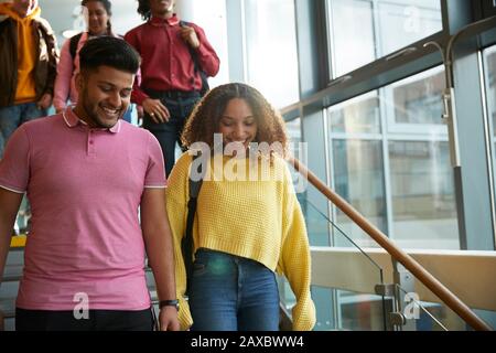 Smiling college students descending staircase Stock Photo