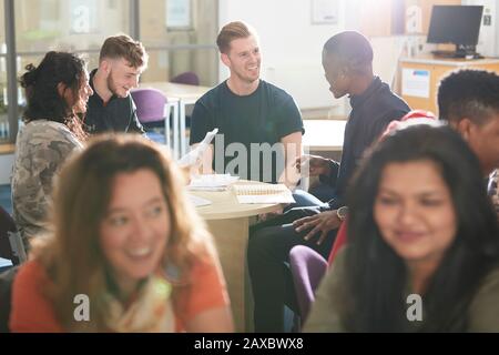 College students studying and talking in sunny classroom Stock Photo