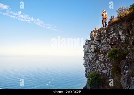 Couple hugging on cliff over sunny ocean Cape Town South Africa