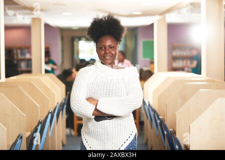 Portrait confident young female college student in library Stock Photo