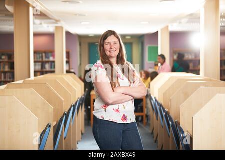 Portrait confident female teacher in library Stock Photo