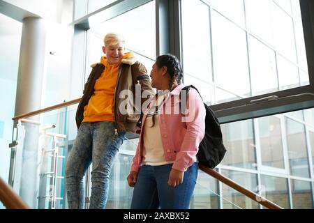 Young female college students talking on staircase Stock Photo