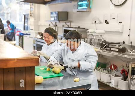 Happy young women with Down Syndrome cooking in cafe Stock Photo