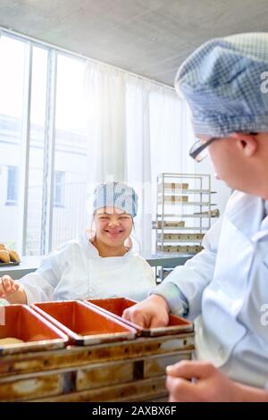 Happy young woman with Down Syndrome baking in kitchen Stock Photo