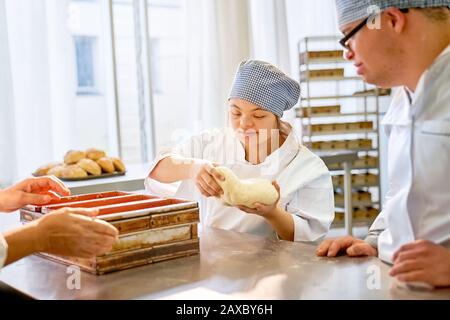 Young students with Down Syndrome baking bread in class Stock Photo