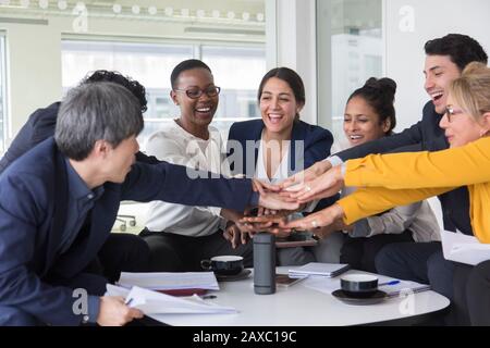 Business people joining hands in meeting Stock Photo