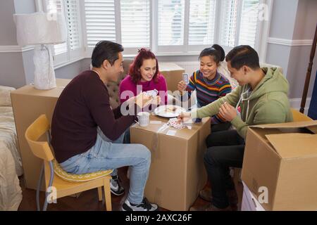 Friends taking a break from moving, playing cards Stock Photo