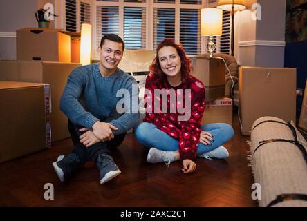 Portrait happy couple taking a break from moving Stock Photo