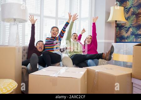 Portrait playful friends taking a break from moving, celebrating and cheering Stock Photo
