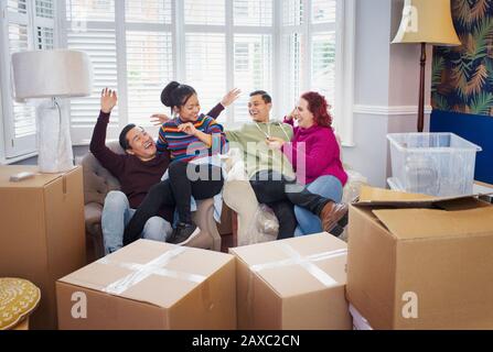 Happy friends taking a break from moving, celebrating Stock Photo