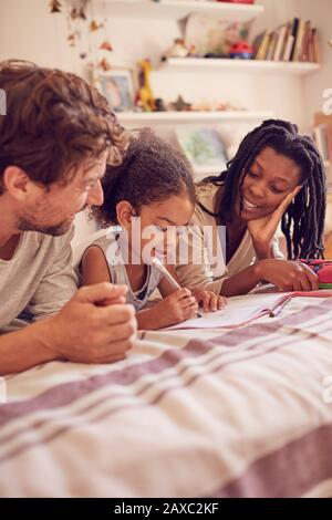 Young family coloring on bed Stock Photo