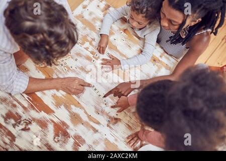 Young family playing scrabble word game at table Stock Photo
