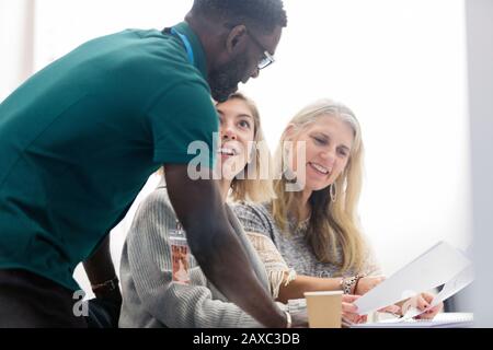 Community college instructor helping students in classroom Stock Photo