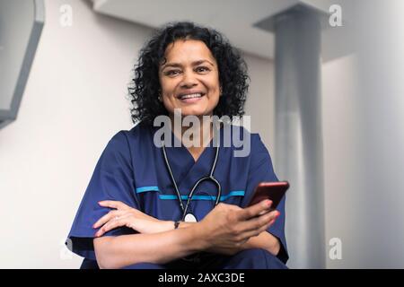 Portrait confident female doctor using smart phone Stock Photo