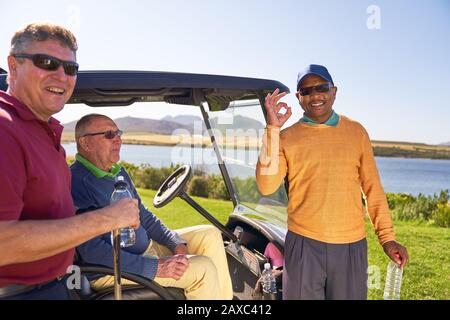 Portrait happy confident male golfer gesturing at sunny golf course Stock Photo