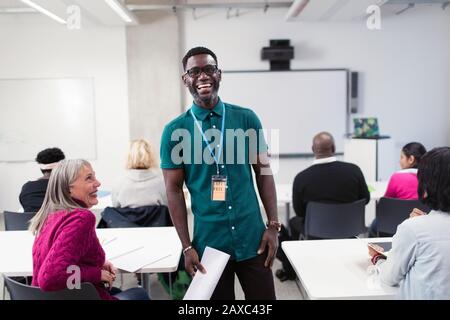 Portrait happy, confident male community college instructor leading lesson in classroom Stock Photo