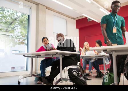Community college students using digital tablet in classroom Stock Photo