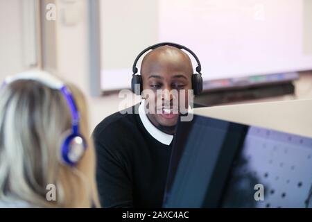Community college students with headphones using computers in computer lab Stock Photo