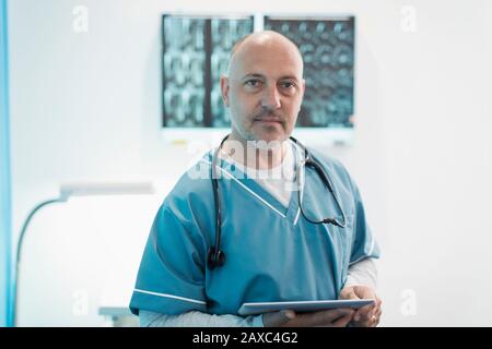 Portrait confident male doctor using digital tablet in hospital Stock Photo