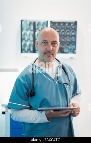 Portrait confident male doctor using digital tablet in hospital Stock Photo
