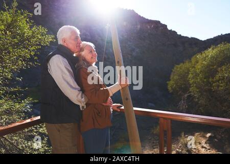 Happy senior couple relaxing on sunny balcony Stock Photo