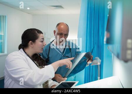 Doctors discussing x-rays in hospital room Stock Photo