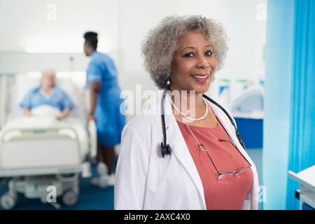 Portrait confident senior female doctor in hospital room Stock Photo