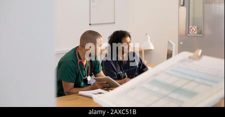 Male nurse and female receptionist using computer in clinic Stock Photo