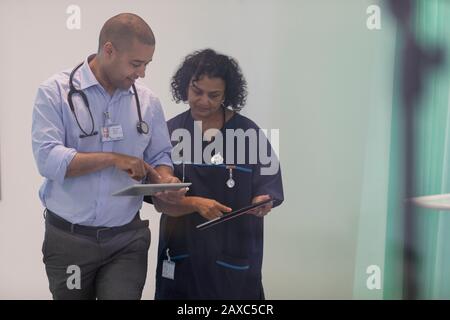 Doctors with digital tablets talking in hospital Stock Photo