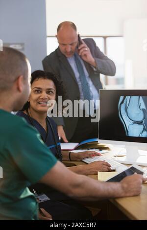 Nurses discussing digital x-ray at computer in clinic Stock Photo